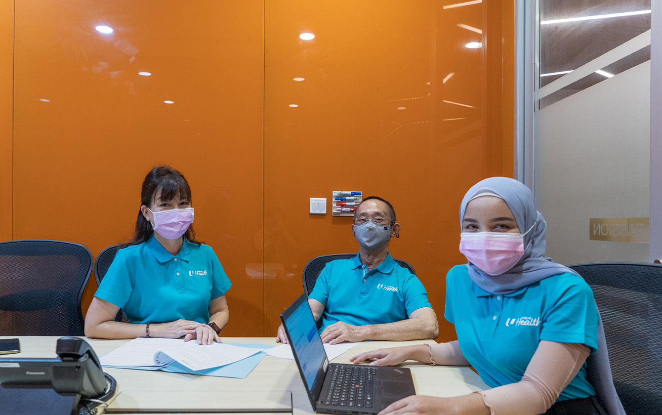 Mr Chong Ooi at NTUC Health interacting with colleagues in meeting room